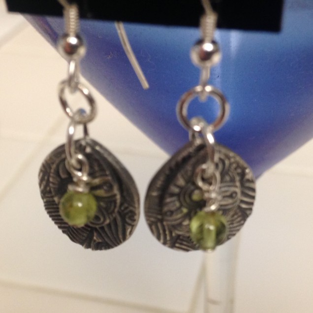 Layered silver pieces accented with Peridot stones.